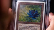 A hand holding a Magic: The Gathering Black Lotus card