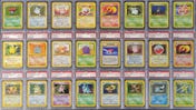 A collage of Pokémon TCG cards from the Fossil set in sealed singles cases as part of an auction item.