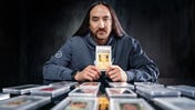 Steve Aoki holding a Pikachu Pokemon card