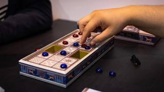 Someone playing the updated version of an ancient board game, Ur: The Royal Game