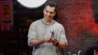 Henry Cavill holding a Warhammer 40,000 miniature.